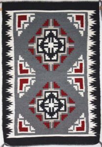Geometric patterned textile with red, black, white, and gray colors.