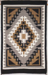 Geometric patterned rug with earthy tones of brown, beige, and black.