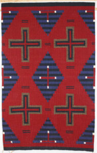 Red and blue textile with geometric cross and diamond patterns.