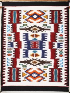 Colorful geometric tribal pattern with diamonds and zigzags.