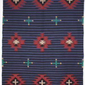 A patterned textile with geometric shapes in red, white, and turquoise on a dark blue background.