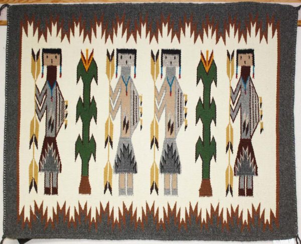 Traditional Native American woven rug with human and tree motifs.