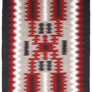 Intricate geometric Navajo textile with red, black, and white patterns.