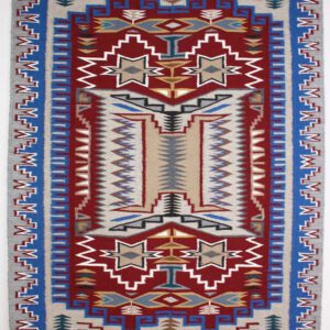 Intricately patterned red, blue, and beige woven rug with geometric designs.